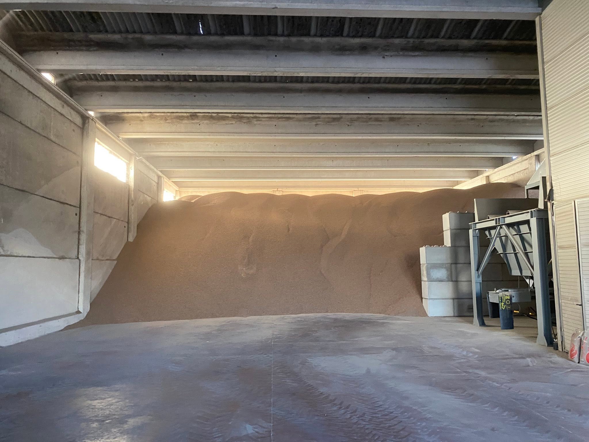 Bulk wood pellets stored inside a warehouse Bulk wood pellets stored inside a warehouse