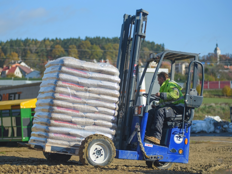 A forklift handling a pallet of bagged wood pellets A forklift handling a pallet of bagged wood pellets